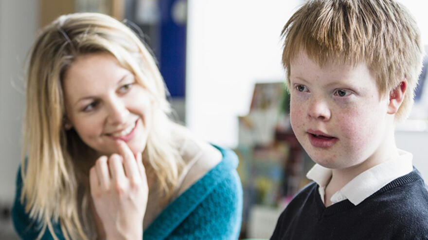 Schoolboy in classroom with female teacher