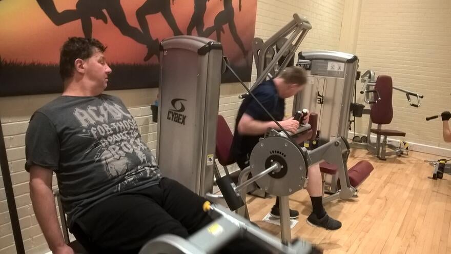 Two men using gym equipment