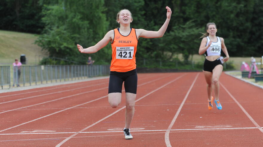Person crossing finish line of running track
