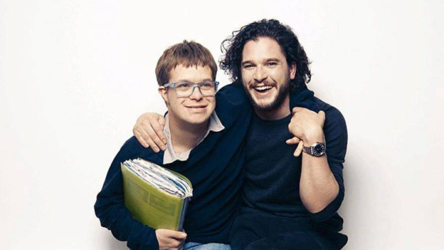 Kit Harington stood with his arm around his cousin, Laurent, who is holding a green book