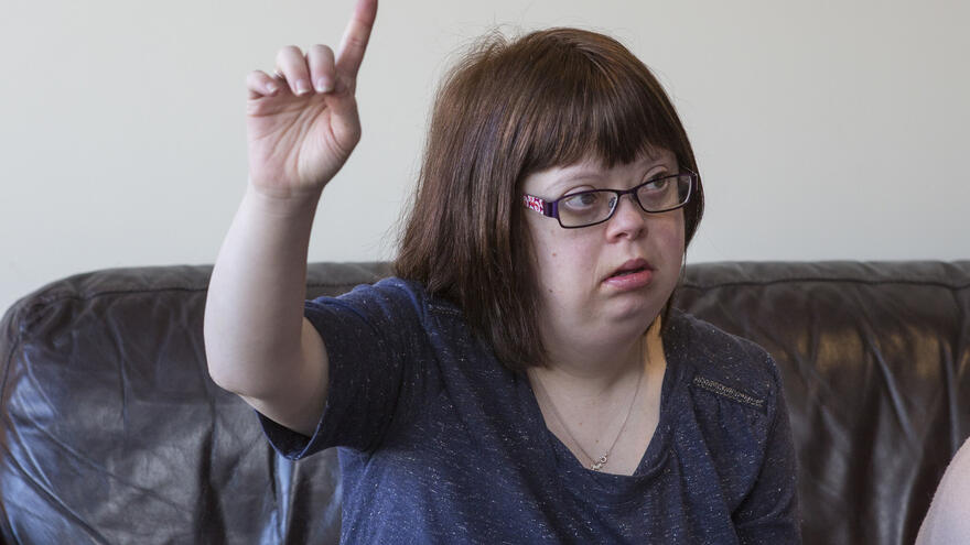 Woman seated with their hand in the air