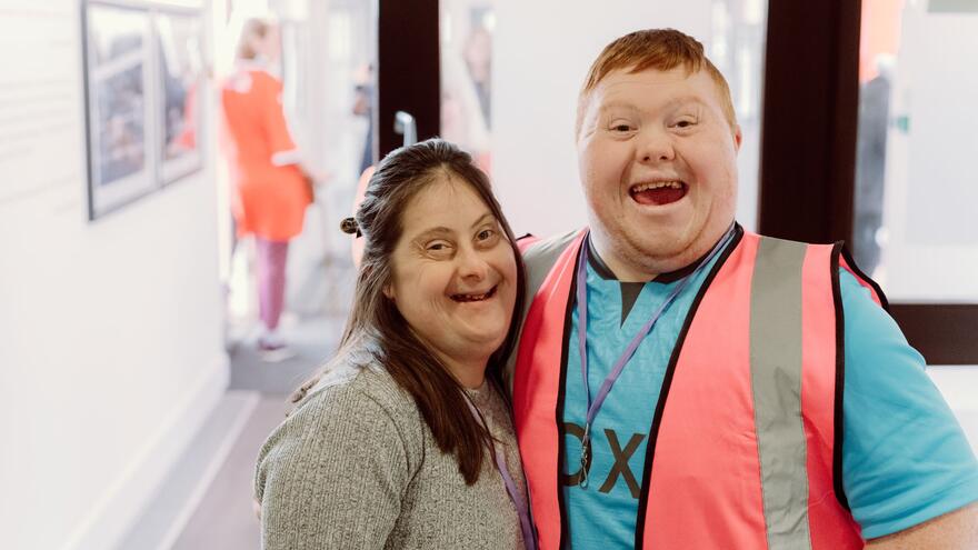 Two people with a learning disability smiling at the camera