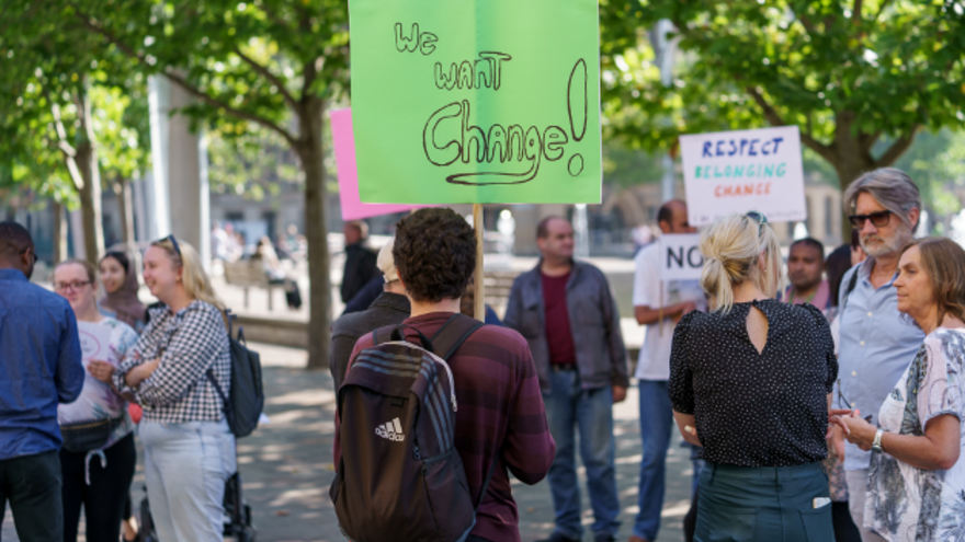 A crowd of people campaigning in the street with signs 
