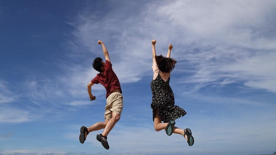 Two children jumping into the sky
