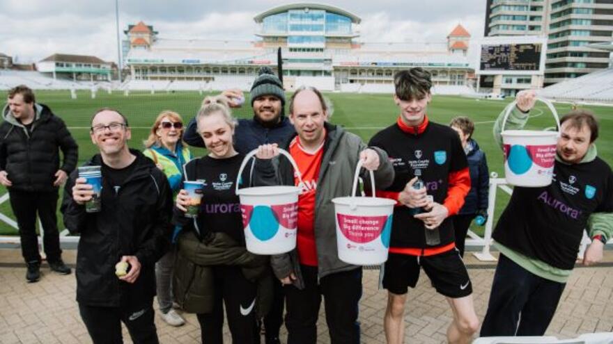 A group of fundraisers with Mencap collection buckets on Nottingham cricket pitch