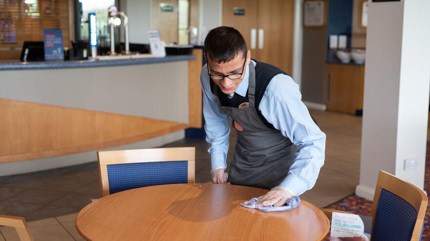 A man cleaning a table.