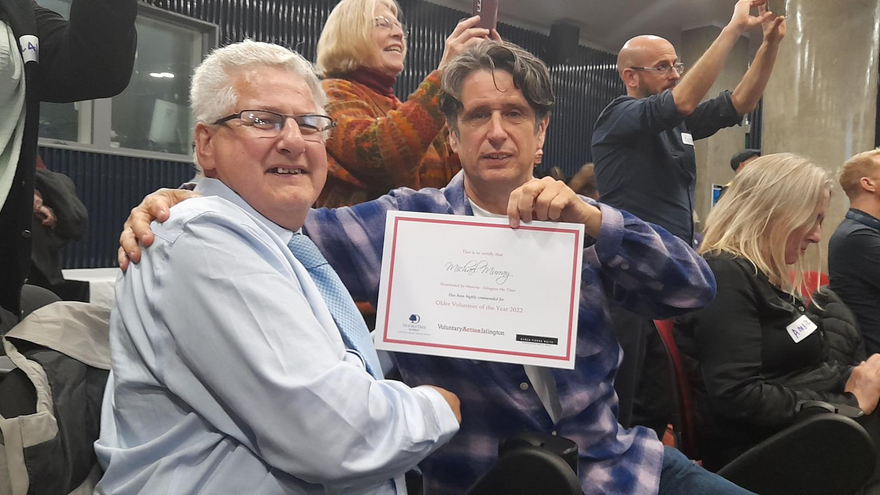 Two men smiling and holding up a certificate.