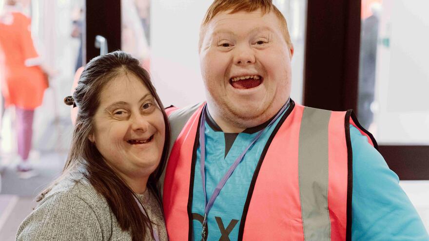 A man and woman with downs syndrome smiling at the camera