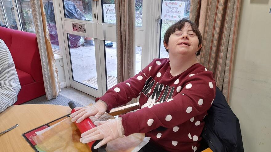 A woman rolling pastry with a rolling pin
