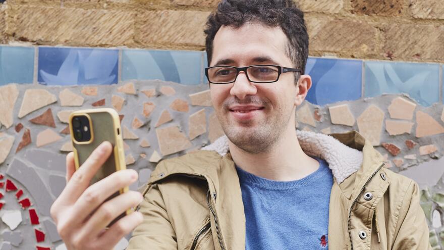 A man smiling at his mobile phone