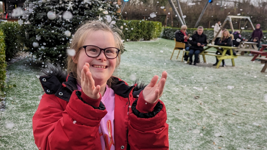 A photograph of Nancy clapping her hands in the snow