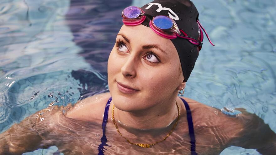 Jessica-Jane in a swimming pool wearing a swimming hat with googles on her head