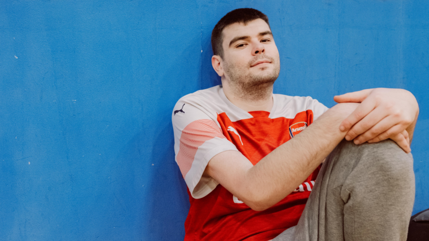 A man is sitting on the floor looking at the camera