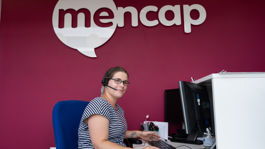 Helpline adviser on the phone whilst using a computer