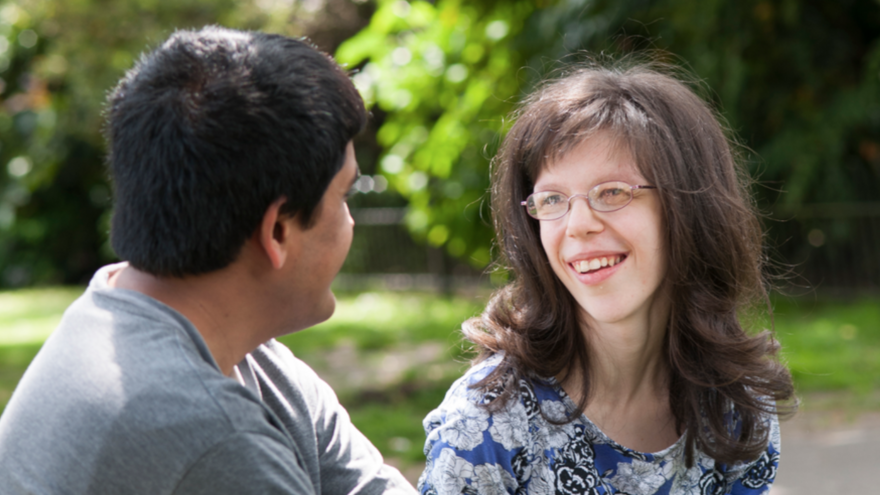 Two people in a park talking 