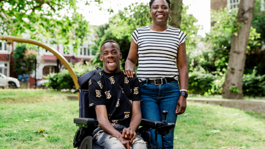 Brendan in a wheelchair with a woman standing next to him in a garden