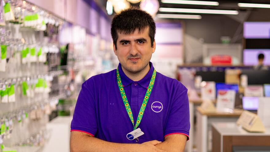 A photograph of Niaz standing in Curry's looking at the camera with his arms folded