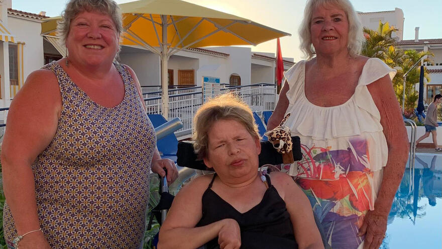 Three women next to a pool on holiday together
