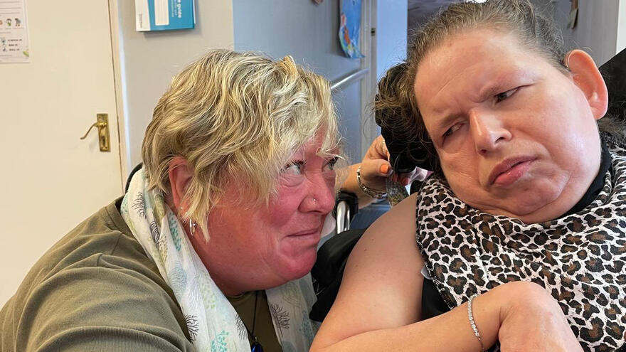 Two women looking at each other with their heads close together