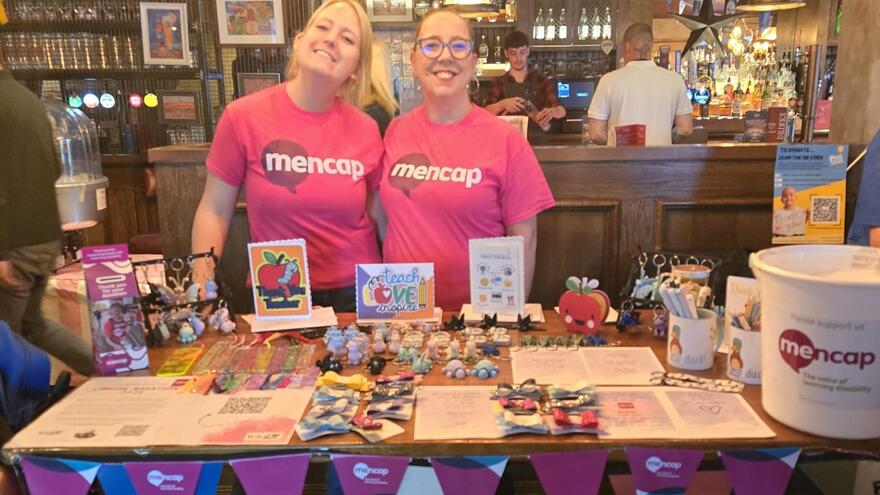 Lucy in a Mencap Tshirt with a friend fundraising for Mencap in a local pub