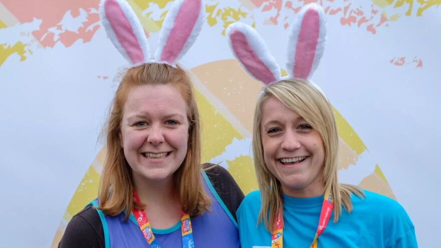 Two Women wearing bunny ears and a medal smiling 