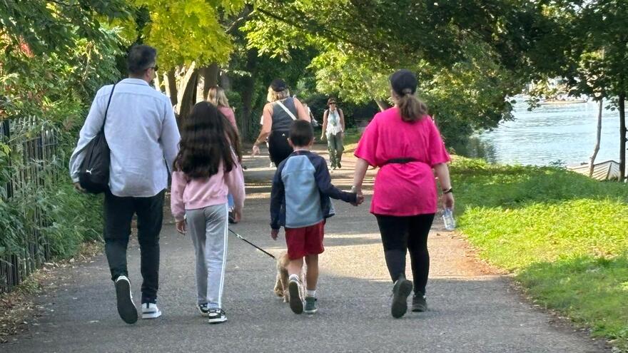 Gina and family walking away from the camera on a path in a park