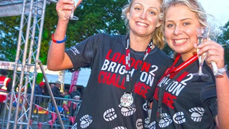 Two Women clinking a glass of fizz at the finish line 