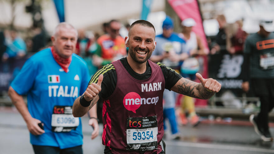 Mencap runner with pink running vest, smiling at the camera