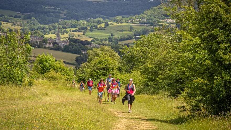 Group of people walking up a hill in the Surrey Hills.
