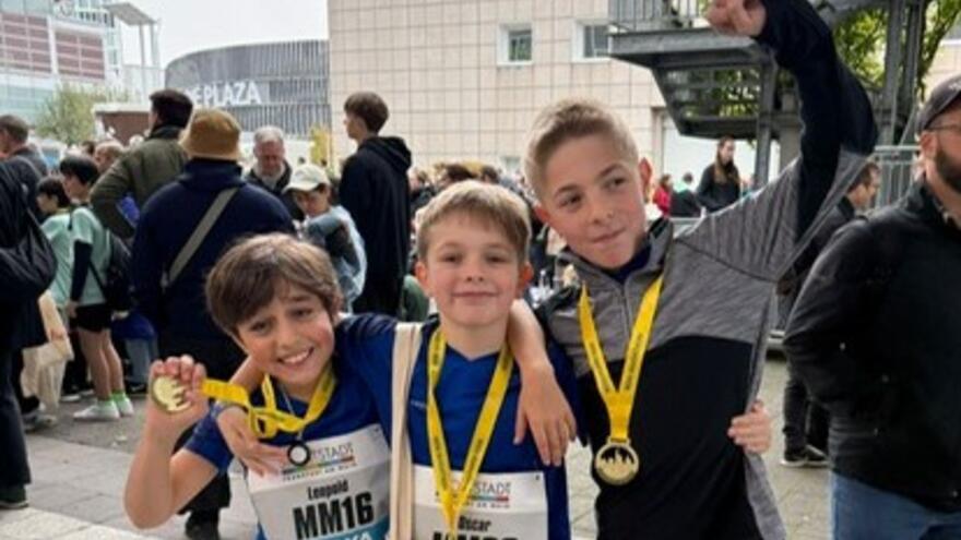 Three mini marathon runners with their medals