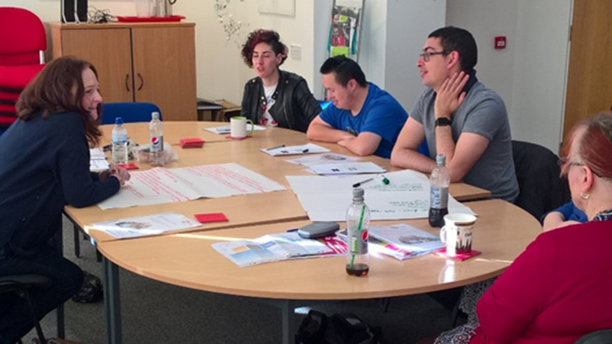 Jonathan sitting at a meeting table with four other people