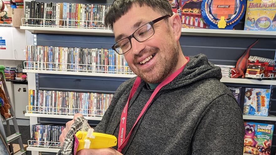 Oliver tagging clothes at the Clifton Mencap shop