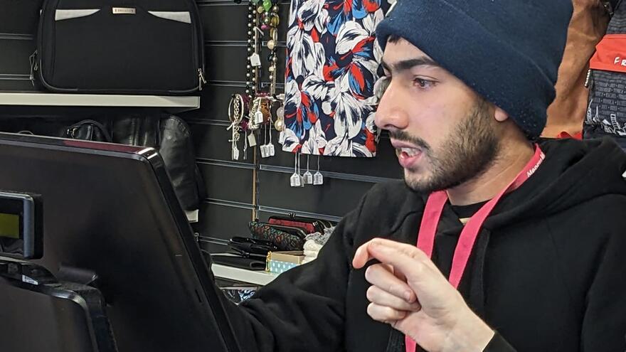 Umair on the till at the Clifton Mencap shop