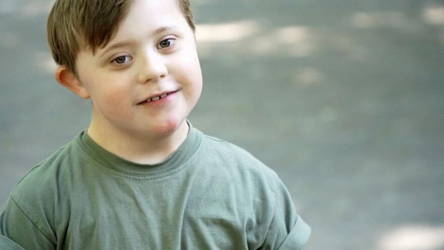 A young boy in a playground looking up to the camera