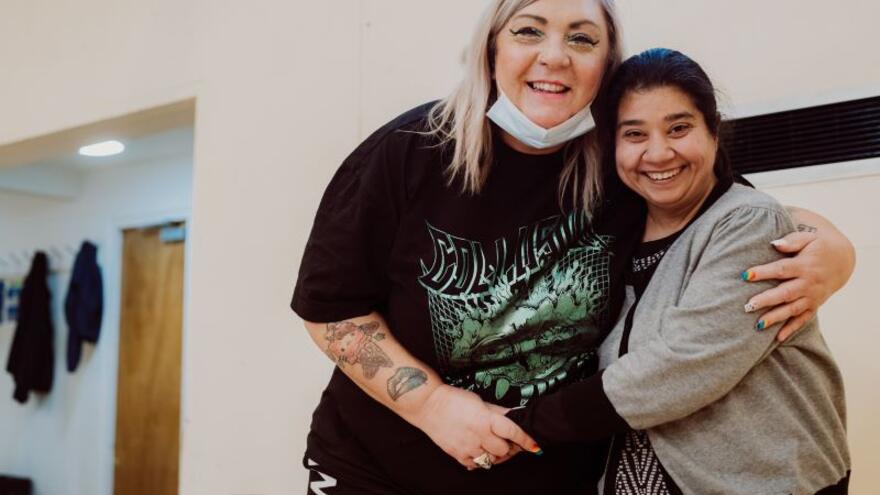 Two women hugging each other whilst looking at the camera