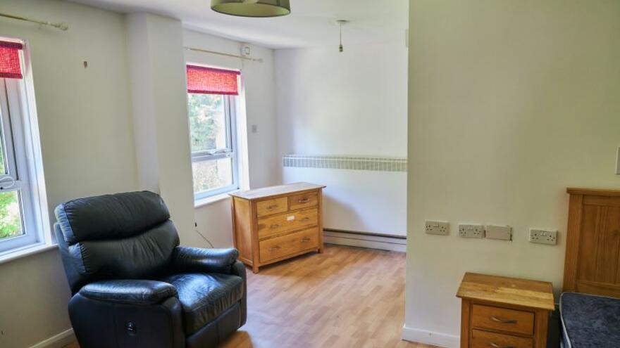 A photograph of a bedroom with two windows