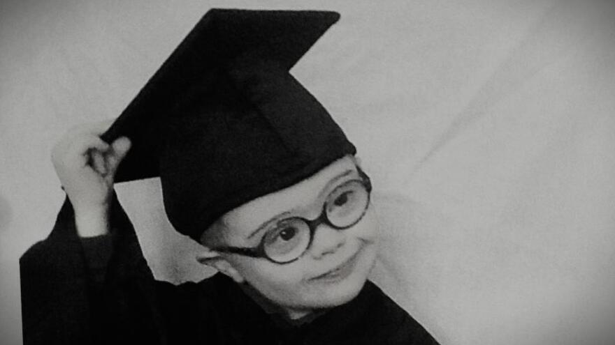 Odhran at a graduation from Mencap nursery wearing a graduation gown and hat
