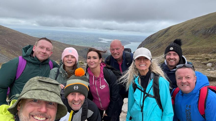 Group of 9 standing on a mountain