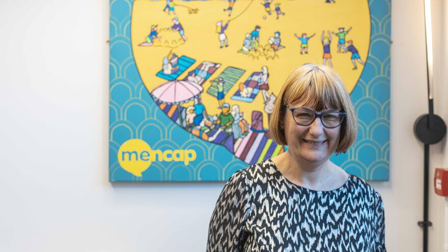 Karen, the Vice-Chair of Mencap's Voice's Council, standing and smiling.