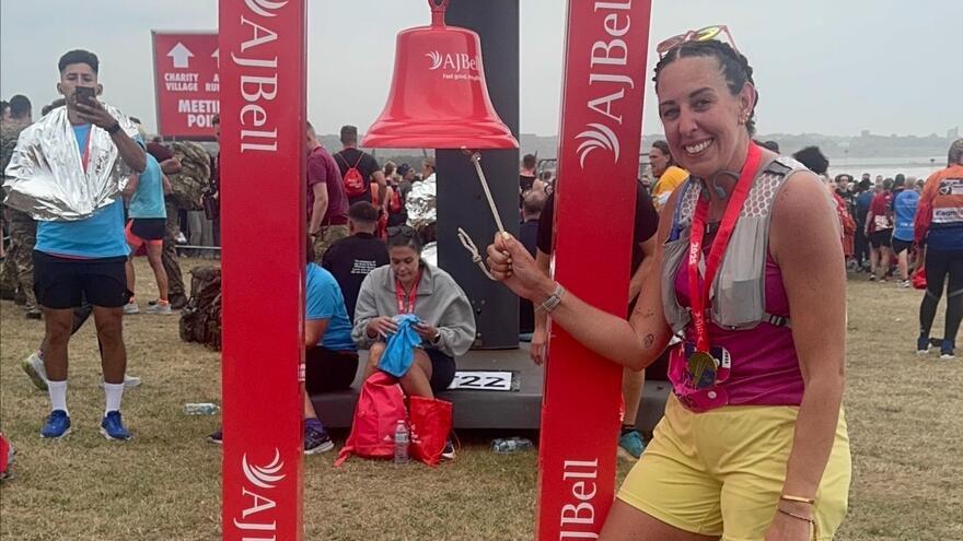 Woman ringing a bell at the end of the Great North Run