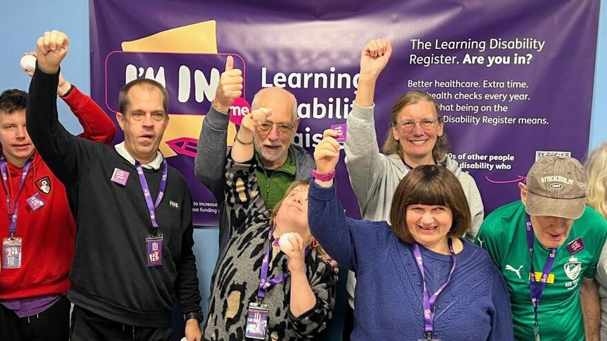 Group of people in front of an I'm In learning disability register poster