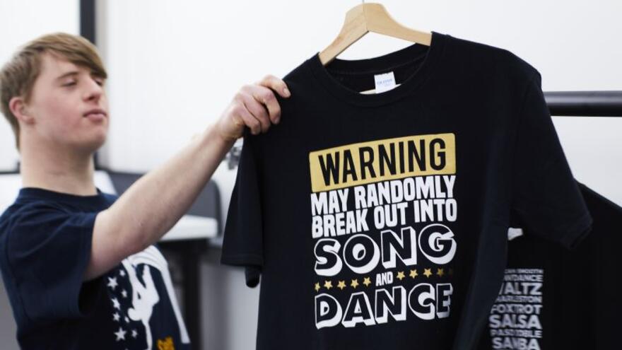 Andrew Self looking at a T shirt on a hanger
