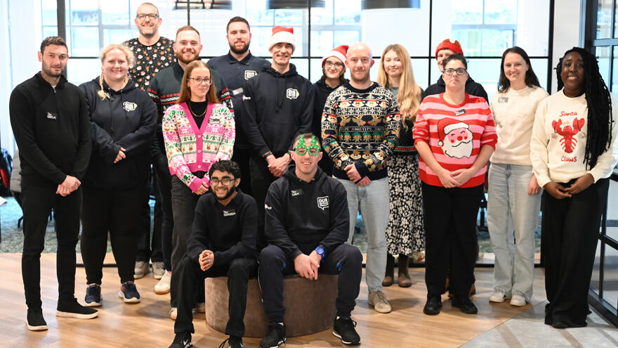 A group of people in an office facing the camera posing for a photograph