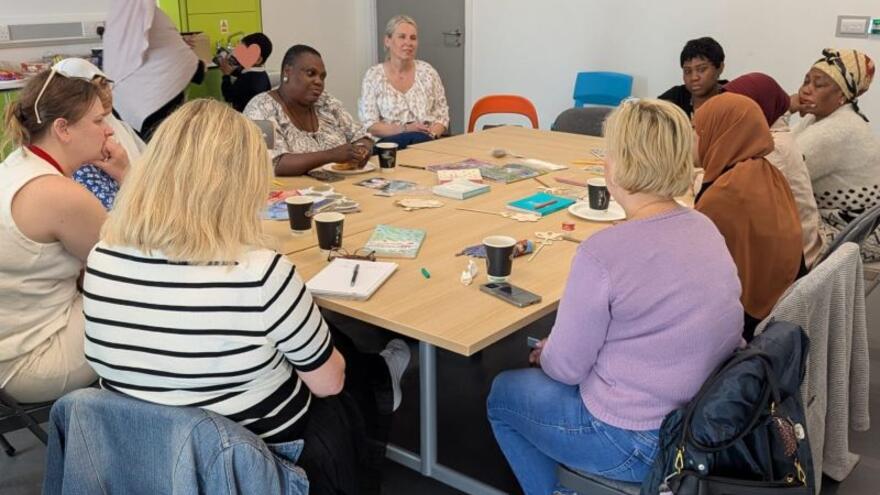 a group of women sitting around a meeting table