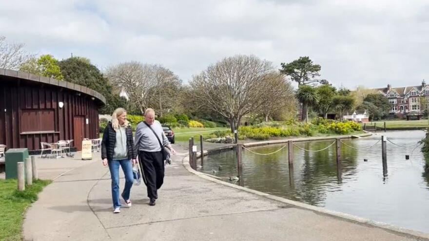 Ronnie and Robin walking in a park next to a lake