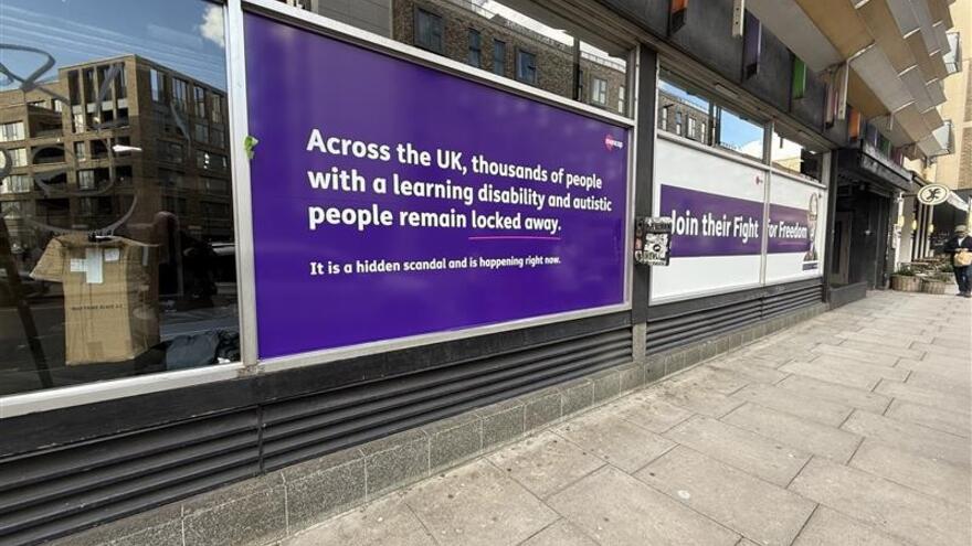A photograph of the exhibition posters on the glass windows of the venue