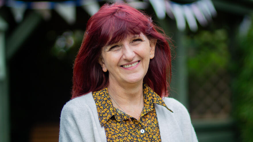 Tracy Welford, a Mencap Area Operations Manager in South Yorkshire is stood outside smiling.