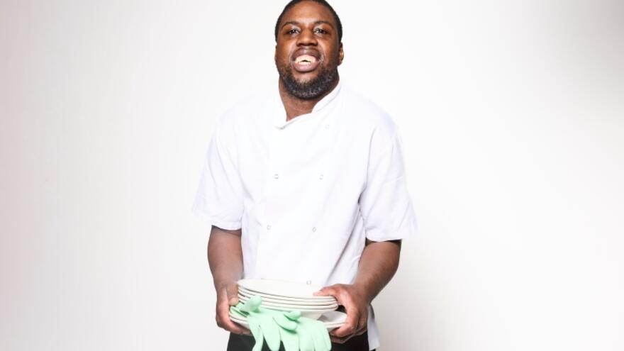 Aaron holding some plates and washing up gloves