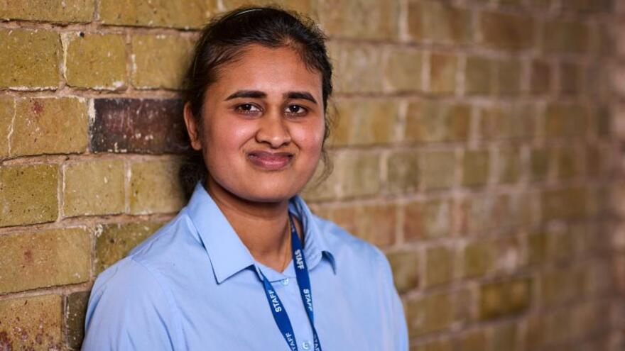Diviyha from the Job Squad standing in front of a brick wall