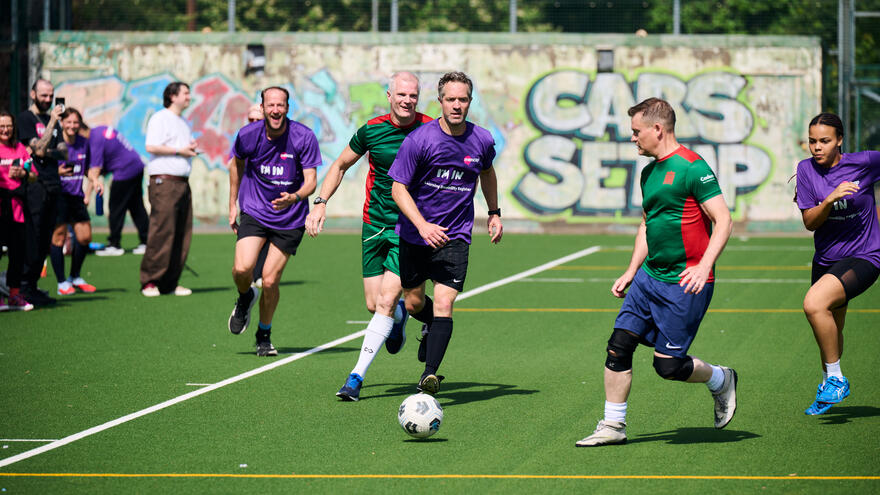 Mencap and MPs football teams mid play on a pitch